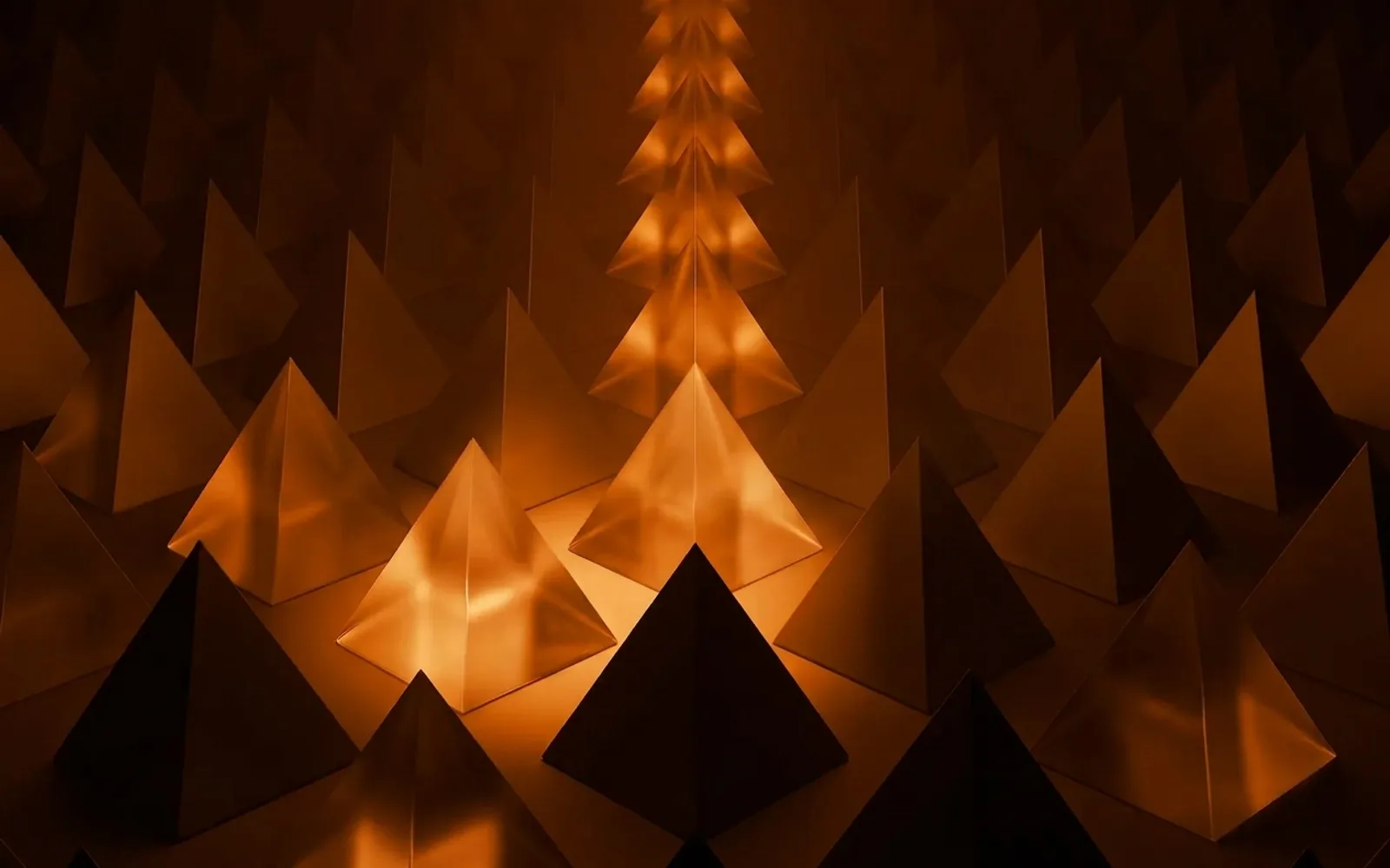 Copertina: piramidi di vetro, luce ambra su fondo nero